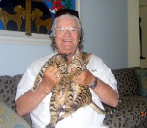 owner holding up two bengal kittens